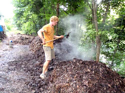 An intern works the lovely steaming compost